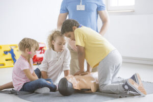 africanamerican boy pressing manikin s chest - Ileria CPR Feedback training technology