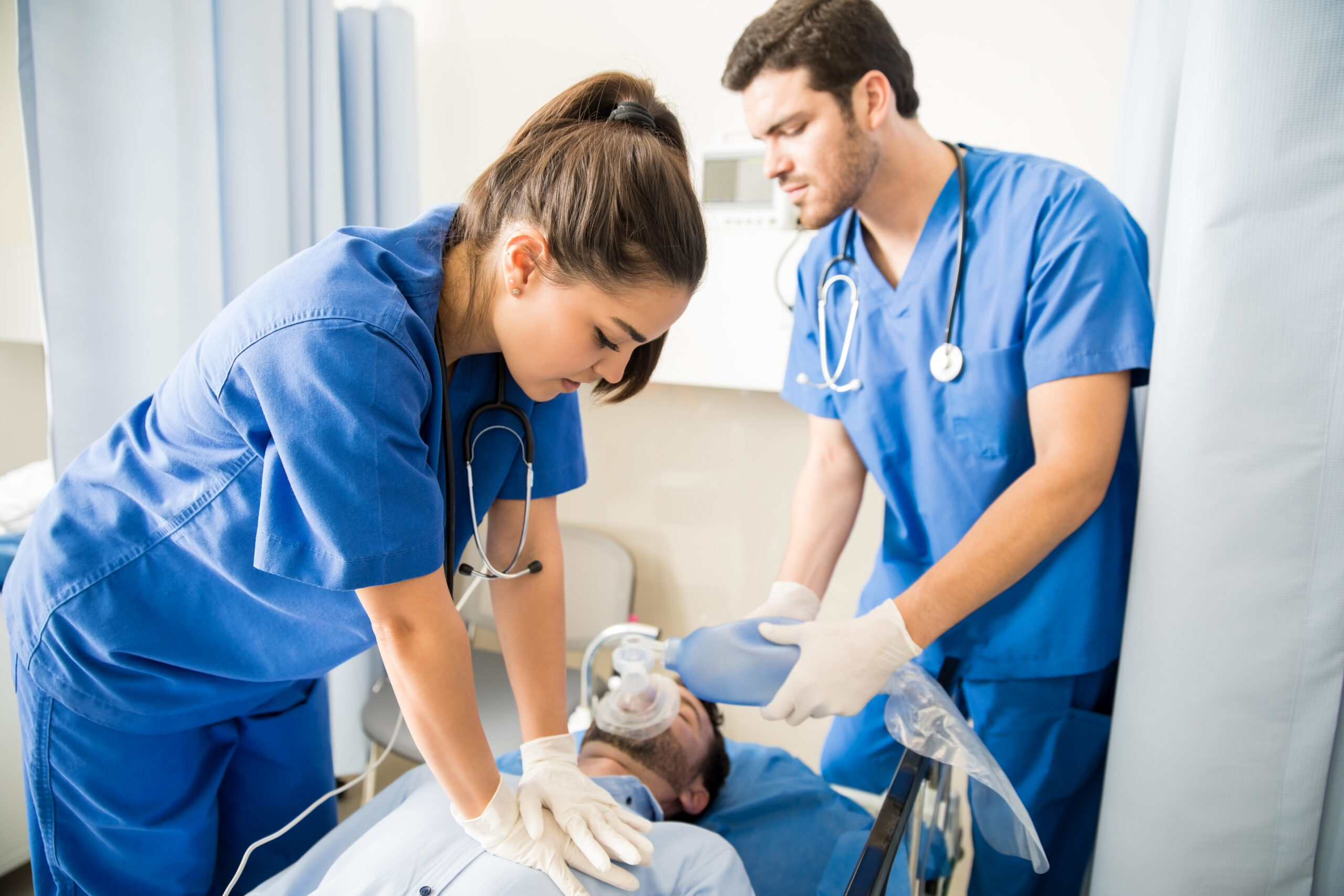 two doctors giving cpr unconscious male patient lying bed emergency room scaled - Ileria CPR Feedback training technology